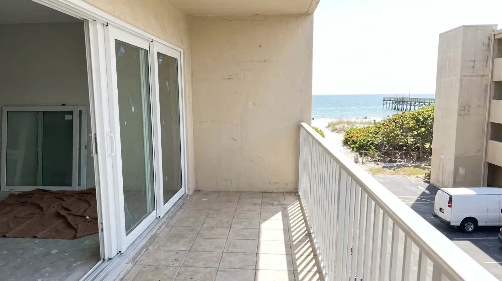 Impact sliding glass door opening onto a condo balcony in Deerfield Beach, FL